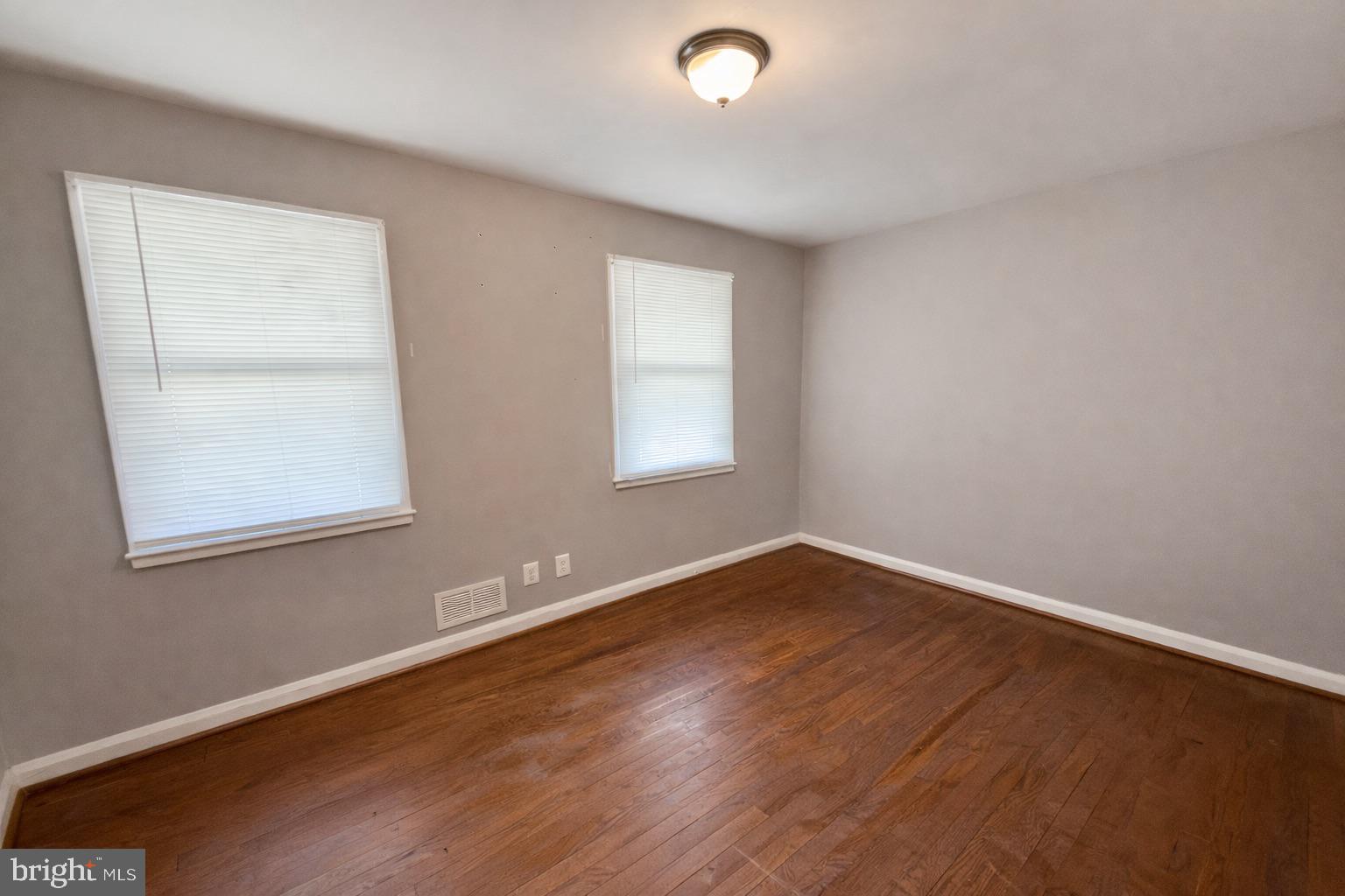 3325 McShane Way Baltimore, MD 21222 - Photo 17 of 23 an empty room with wooden floor and windows
