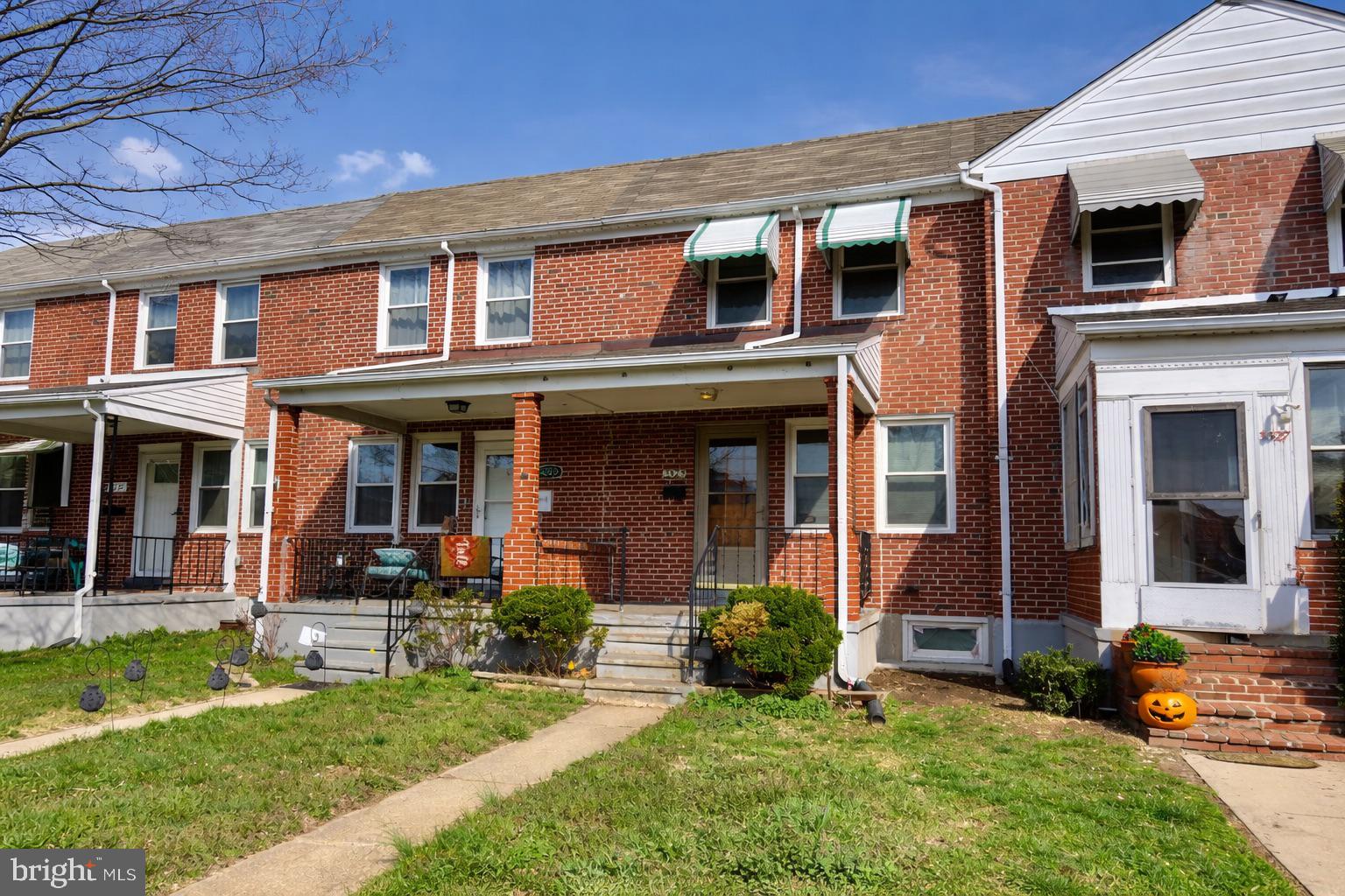 3325 McShane Way Baltimore, MD 21222 - Photo 2 of 23 front view of a brick house with a yard