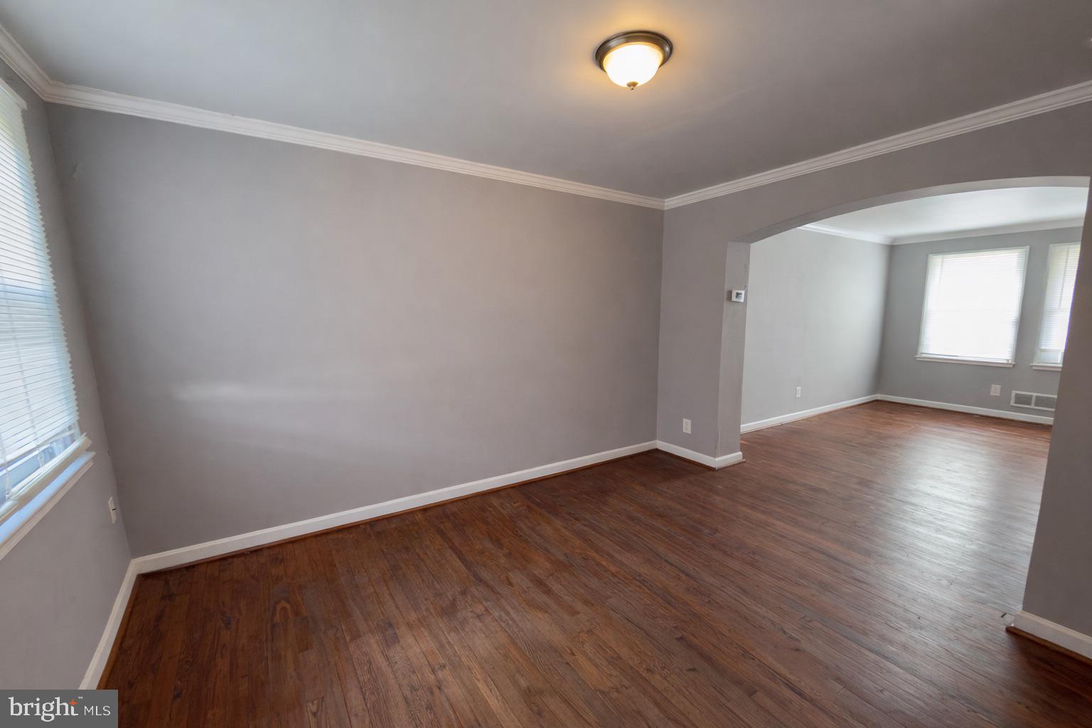 3325 McShane Way Baltimore, MD 21222 - Photo 8 of 23 an empty room with wooden floor and windows