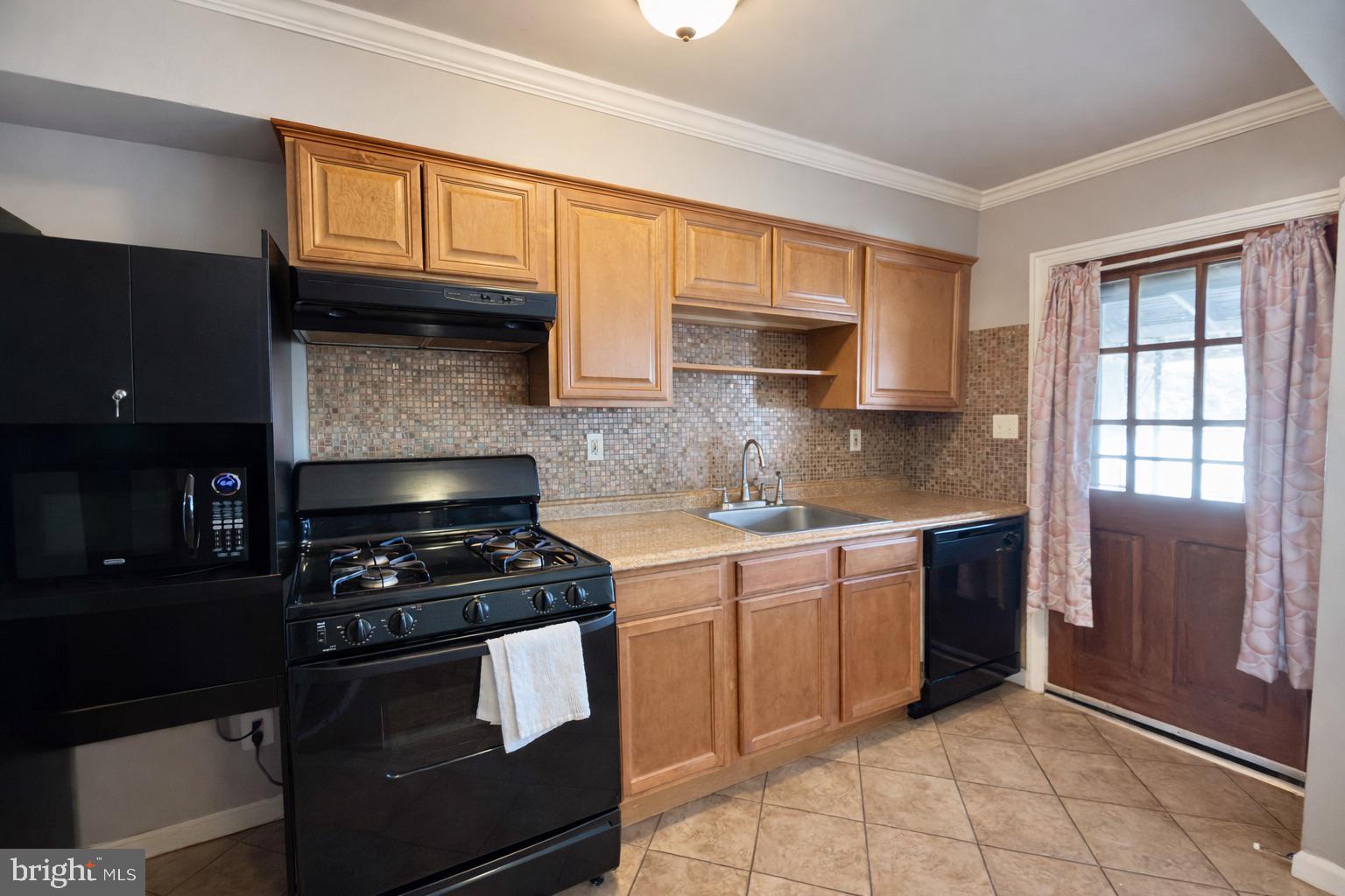 3325 McShane Way Baltimore, MD 21222 - Photo 10 of 23 a kitchen with granite countertop a stove a sink and a cabinets