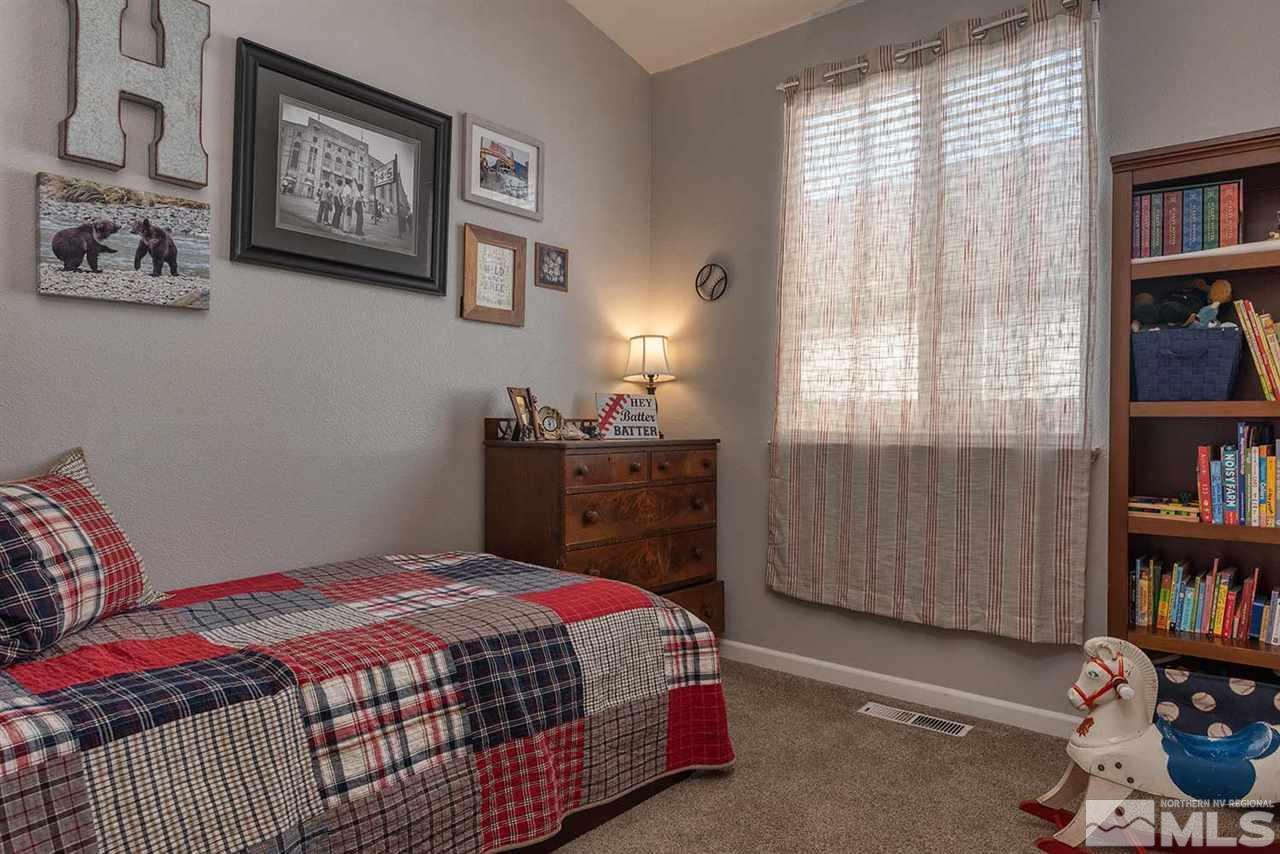 5540 Daybreak Drive Reno, NV 89523 - Photo 18 of 23 a bedroom with a bed and a book shelf