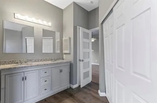 a bathroom with a granite countertop sink two mirror and a