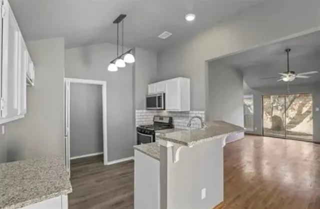 a view of a kitchen and a sink windows wooden floor