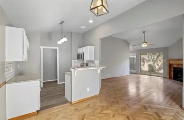 a view of a kitchen with a sink dishwasher and a fireplace