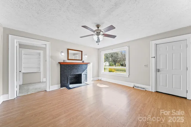 a view of an empty room with a window and a ceiling fan