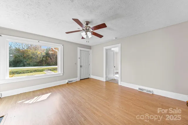 a view of main area fire place window and wooden floor