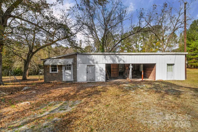 a view of backyard with large trees and wooden fence