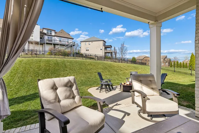 a view of a patio with couches chairs and a big yard