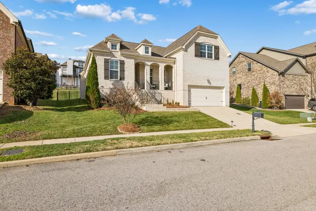 a view of a white house with a yard and plants