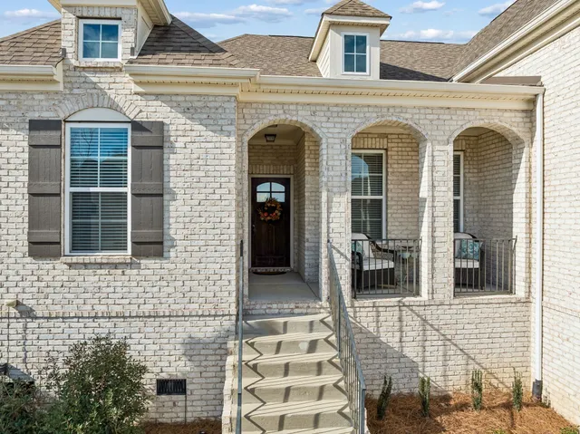 a view of a brick house with large windows