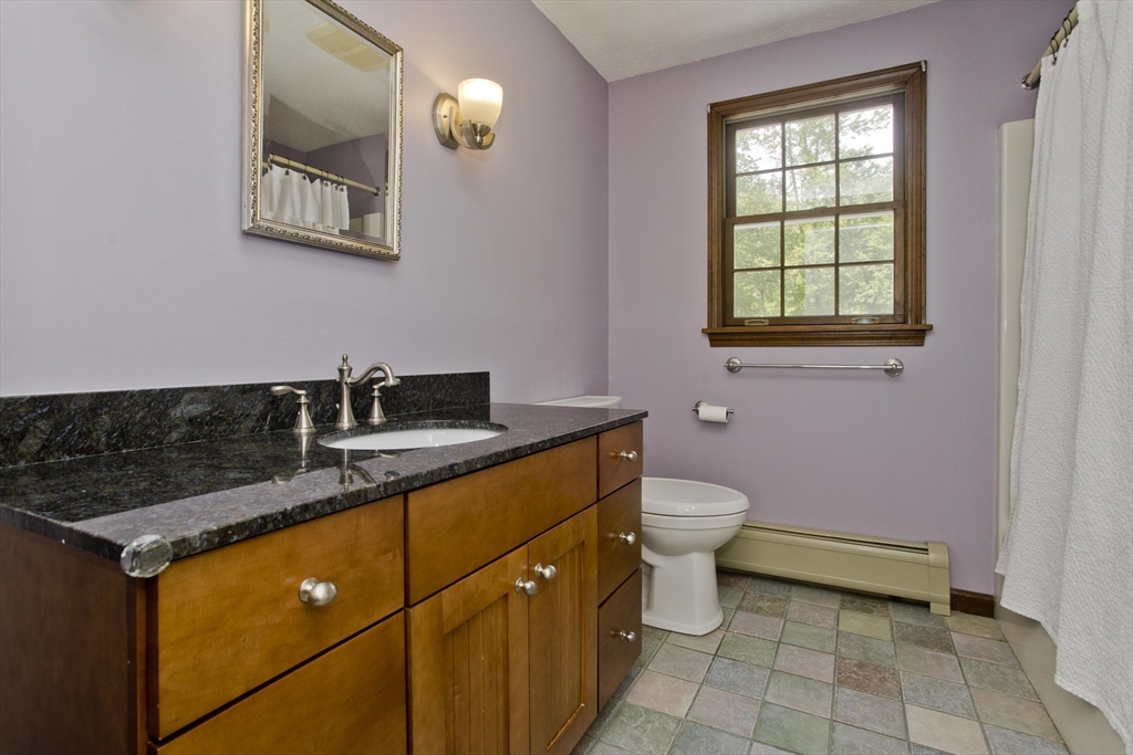 581 Burts Pit Road Northampton, MA 01062 - Photo 24 of 35 a bathroom with a granite countertop sink a toilet and mirror