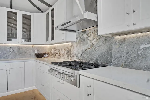 a kitchen with a stove and white cabinets