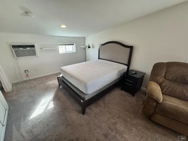 a bedroom with a bed window and couch