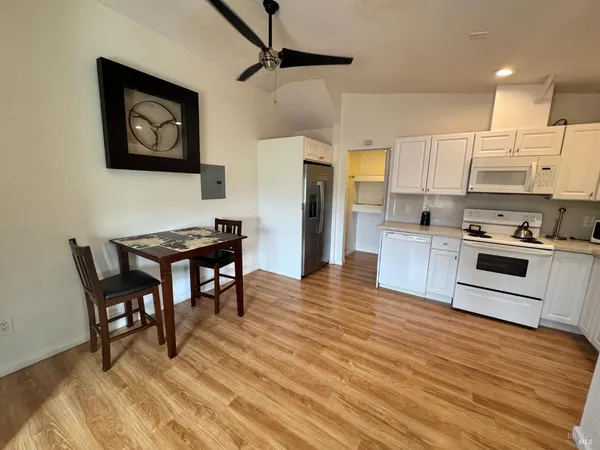 a kitchen with stainless steel appliances wooden floor and a refrigerator