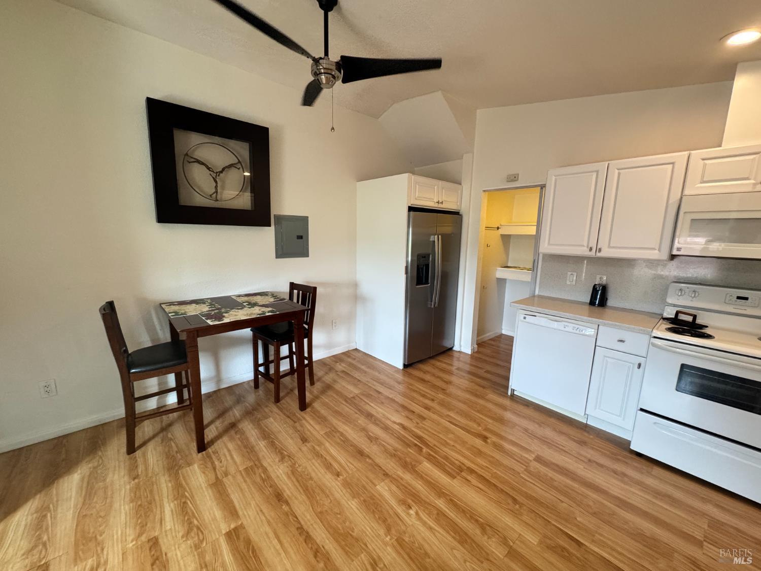 3753 Santa Rosa Avenue, Unit E Santa Rosa, CA 95407 - Photo 6 of 16 a kitchen with stainless steel appliances granite countertop a stove a refrigerator a dining table and chairs with wooden floor