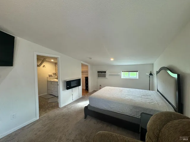 a bedroom with a bed and a flat screen tv