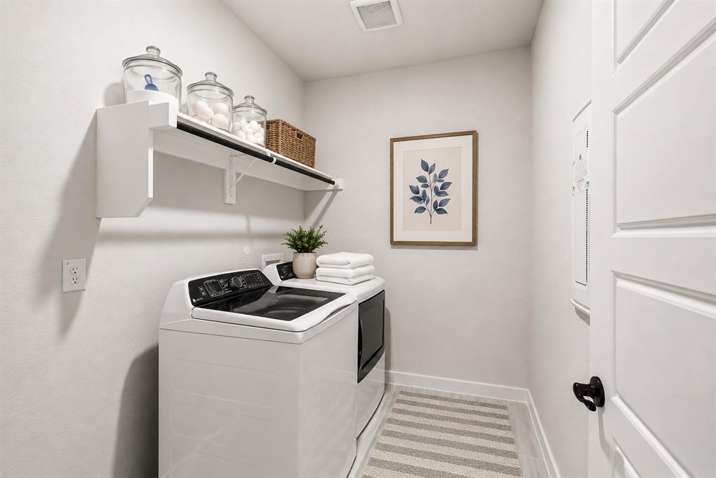 3311 Willena Road Melissa, TX 75454 - Photo 22 of 40 Dedicated utility space featuring a top-load washing machine, built-in shelving, white paneled door, light-toned wall paint, and wood-finish flooring