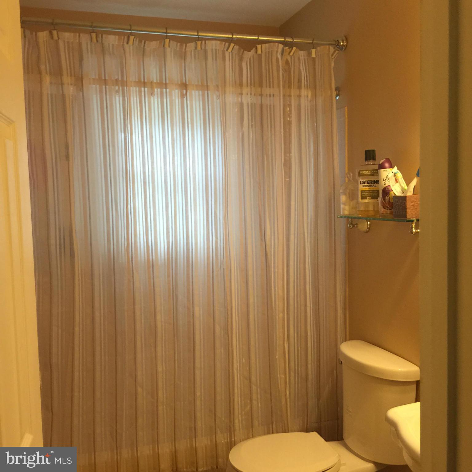 14909 Schall Road Accokeek, MD 20607 - Photo 11 of 22 a white toilet sitting next to a shower curtain