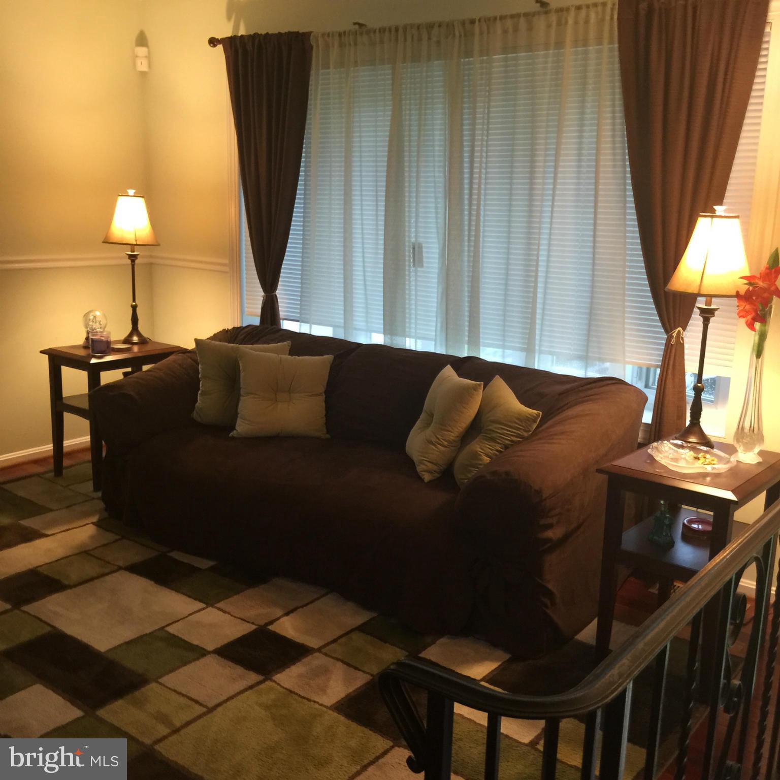 14909 Schall Road Accokeek, MD 20607 - Photo 3 of 22 a living room with a couch and a potted plant