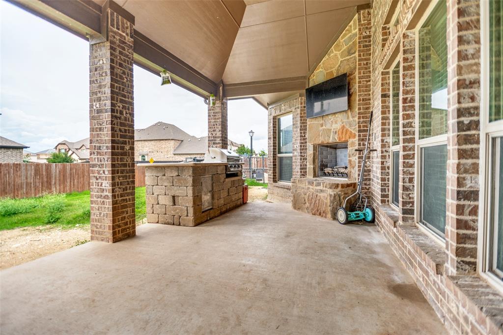 413 Frontier Court Midlothian, TX 76065 - Photo 23 of 26 Covered patio featuring an outdoor kitchen with built-in grill, a stone fireplace, and brick columns