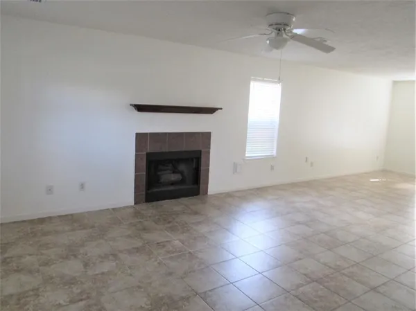an empty room with windows and fireplace