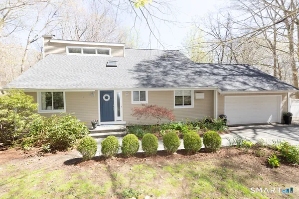 a front view of a house with a yard outdoor seating and pathway