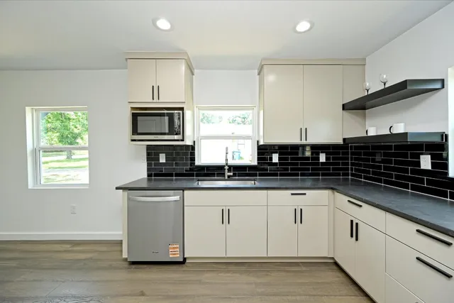 a kitchen with stainless steel appliances granite countertop a sink and a stove