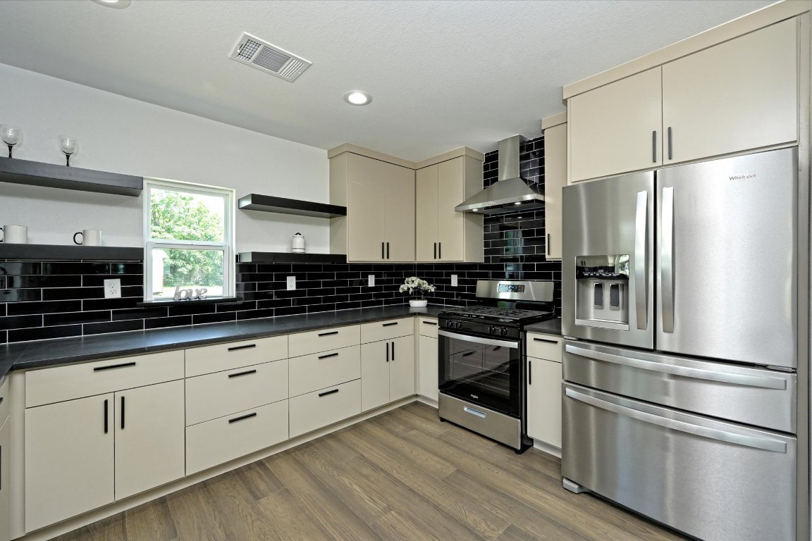 710 East 2nd Street Elgin, TX 78621 - Photo 13 of 30 a kitchen with stainless steel appliances granite countertop a refrigerator and a stove