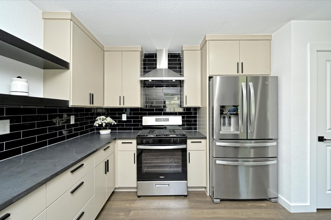 710 East 2nd Street Elgin, TX 78621 - Photo 14 of 30 a kitchen with a refrigerator stove and wooden cabinets