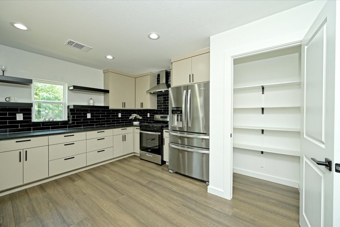 710 East 2nd Street Elgin, TX 78621 - Photo 15 of 30 a kitchen with granite countertop a refrigerator and a stove top oven
