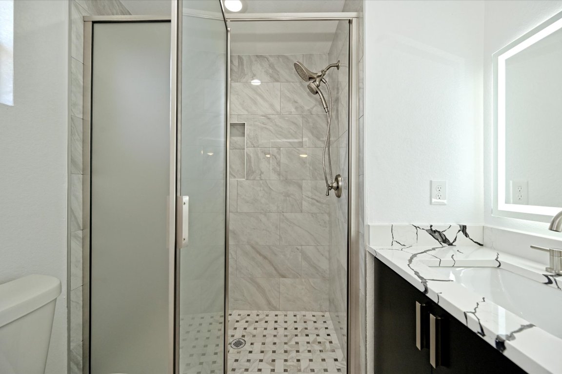 710 East 2nd Street Elgin, TX 78621 - Photo 20 of 30 a bathroom with a granite countertop shower sink and mirror