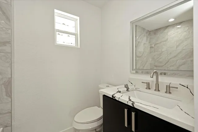a bathroom with a sink toilet and a mirror