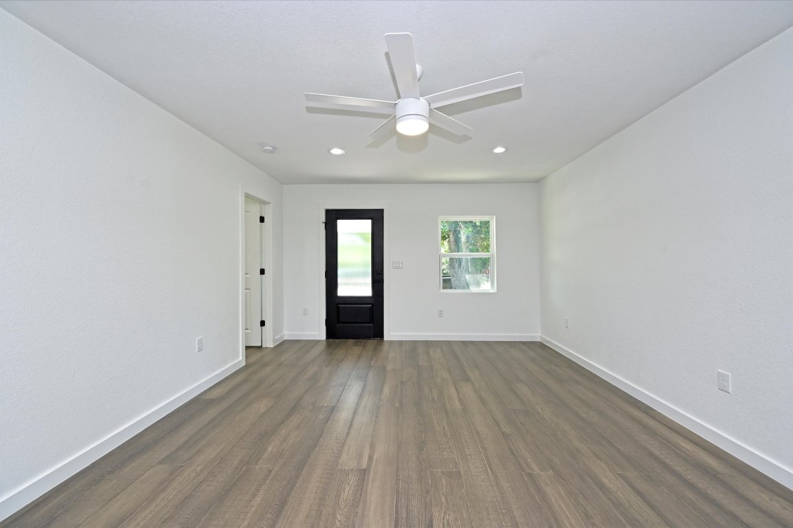 710 East 2nd Street Elgin, TX 78621 - Photo 5 of 30 an empty room with wooden floor chandelier fan and windows