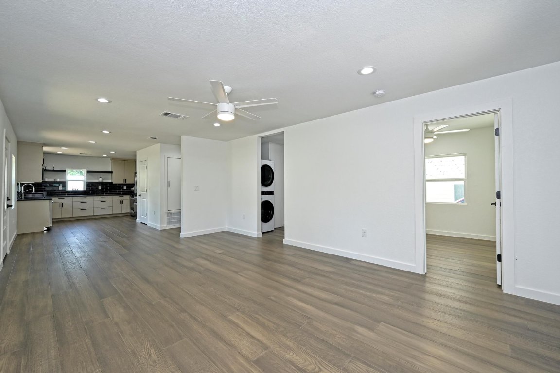 710 East 2nd Street Elgin, TX 78621 - Photo 6 of 30 an empty room with wooden floor kitchen view and a window