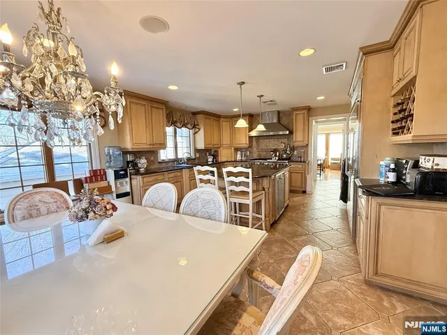 a large white kitchen with lots of counter space dining table and chairs