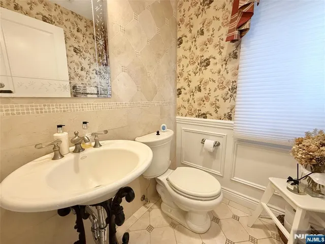 a bathroom with a sink a toilet and a mirror