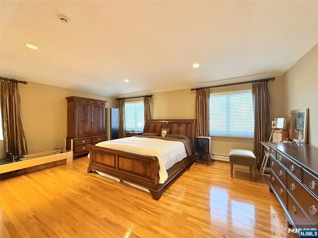 a spacious bedroom with a large bed and a chandelier