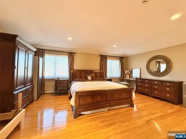 a bedroom with a bed and a dresser with mirror