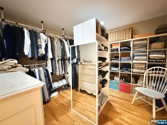 a view of walk in closet with clothes and shoes