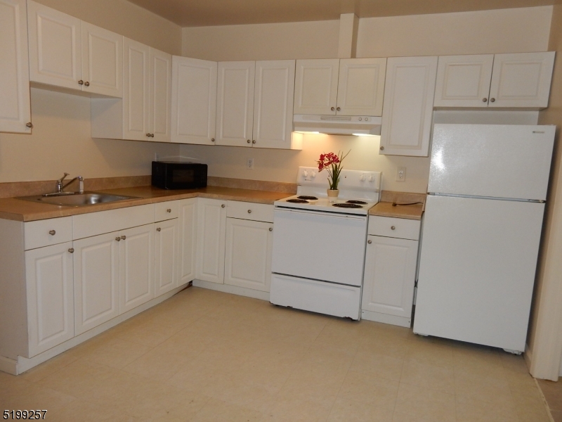134 Main Street, Unit 3 Netcong, NJ 07857 - Photo 3 of 10 a kitchen with white cabinets sink and white appliances