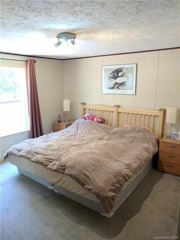 2158 Coopers Gap Road Rutherfordton, NC 28139 - Photo 15 of 27 a large bed sitting in a bedroom next to a window