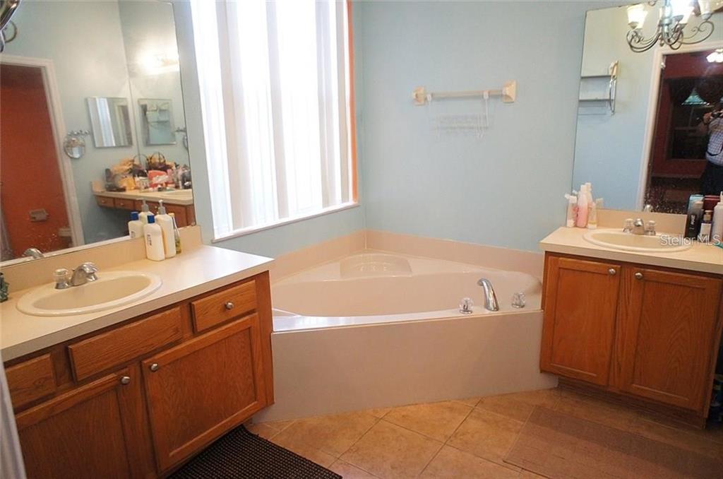 5948 Winchester Isle Road Orlando, FL 32829 - Photo 13 of 23 a bathroom with a tub sink and mirror