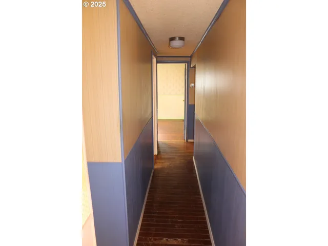 a walk in closet with wooden floor