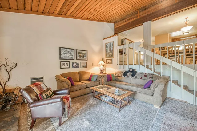 a living room with furniture a flat screen tv and a floor to ceiling window