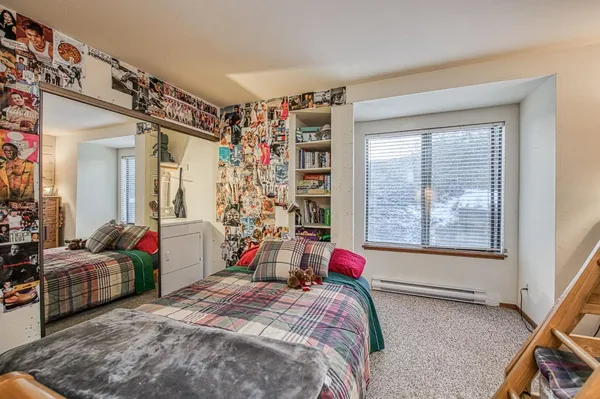 a bedroom with a bed a flat screen tv and a window