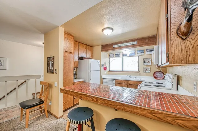 a kitchen with stainless steel appliances granite countertop a sink and a stove next to a window