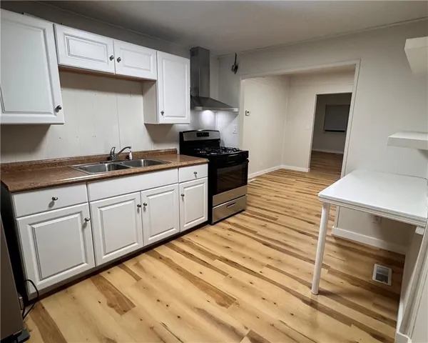 a kitchen with white cabinets appliances and a sink