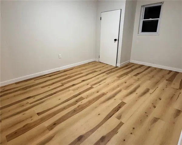 a view of room with wooden floor and white walls