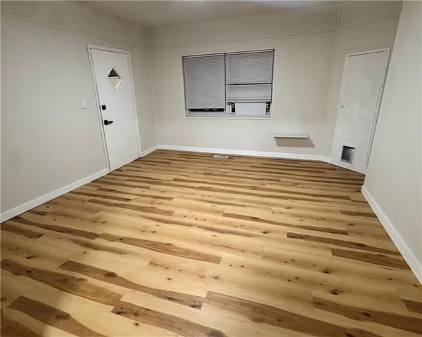 a view of a room with wooden floor