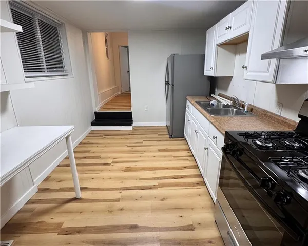 a kitchen with sink stove and refrigerator